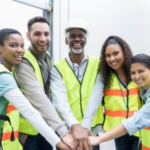 workers in safety vests puts hands in together
