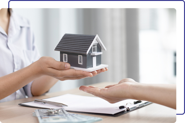 Two people exchanging a little house figurine