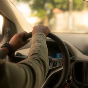 Someone with both hands on the steering wheel